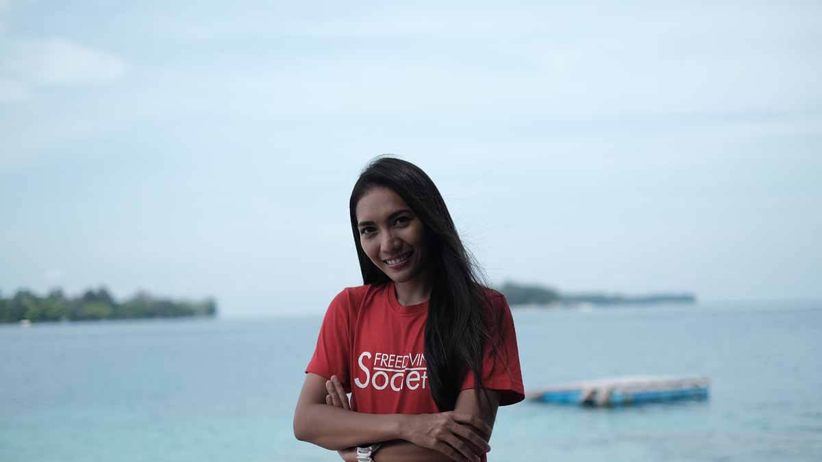 Nikita Fima menggunakan t-shirt merah mertuliskan "Freediving Society"